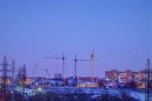 Qualifying Bidders, construction crane amidst suburban town and housing estates