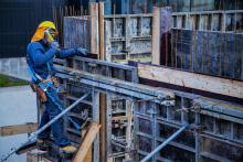 Institutional Responsibilities: Implementation, worker on steel structure working on building framework