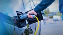 Innovative Revenues for Infrastructure,Free photo man plugging in charger into an electric car at charge station