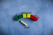 Environmental Risk Management, colorful wooden cubes and chalkboard risk indicator, risk meter