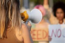 Political Risk Insurance, photo close up woman holding megaphone